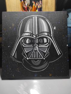 a darth vader star wars painting on a black and white canvas with colored pencils in the background