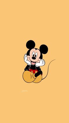 mickey mouse sitting on the ground with his arms crossed and eyes closed, in front of an orange background