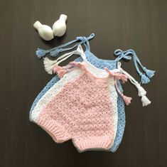 a crocheted baby bib and two small white birds on a table top