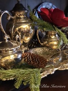 silver tea set with pine cone and red rose