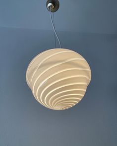 a white light hanging from the ceiling in a room with blue walls and flooring