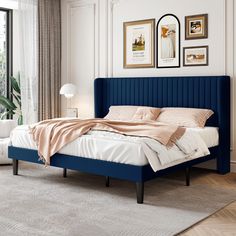 a bed with blue headboard and foot board in a white room next to a window