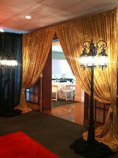 a red carpeted room with gold drapes and chandeliers