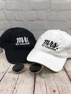 two hats and sunglasses sitting on top of a wooden table