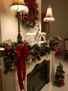 a fireplace decorated for christmas with red and gold decorations on the mantel, deer figurines and lights