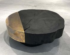 a table made out of wood and metal with a black surface on the bottom half