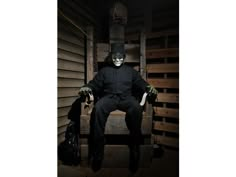 a man sitting in a chair wearing a creepy mask