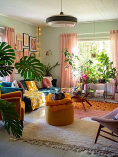 a living room filled with furniture and lots of plants