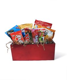 a red box filled with assorted snacks and candy bar wrappers on top of it