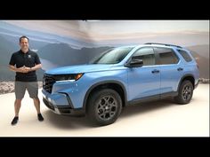 a man standing next to a blue suv