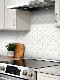 a stove top oven sitting inside of a kitchen next to white cabinets and counter tops