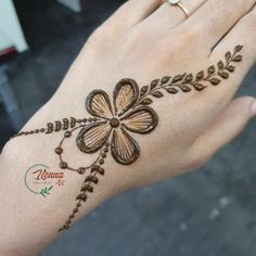 a woman's hand is decorated with hendi and flower designs on her palm