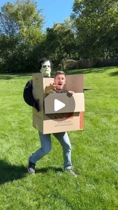 a man is holding a cardboard box with a mask on his head and an open mouth