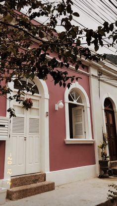 a pink house with white trim and windows