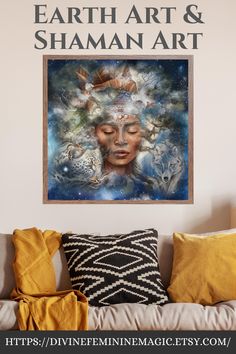 a couch with pillows on top of it and a painting above the couch that says earth art & shaman art