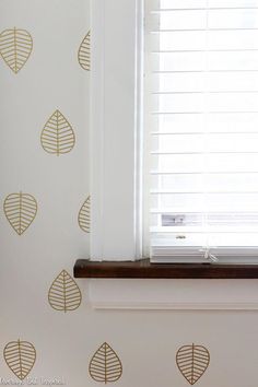 the window sill is decorated with gold leaf stencils on a white wall