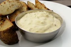 a white plate topped with slices of bread and dip