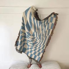 a blue and white blanket sitting on top of a pillow