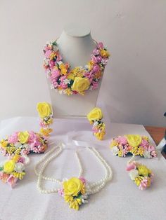 a necklace, bracelet, and earrings made out of fake flowers on a mannequin