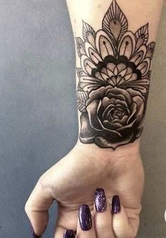 a woman's hand with a flower tattoo on it