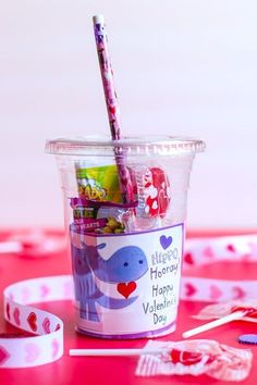 a plastic cup filled with valentine's day candies and a toothbrush in it