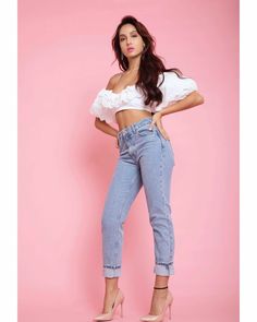 a woman in high rise jeans posing for the camera with her hands on her hips