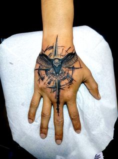 a person's hand with a tattoo on it and a cross in the middle