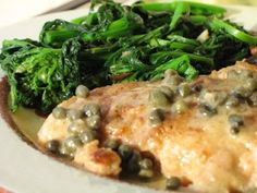 a white plate topped with meat covered in sauce and green beans next to broccoli