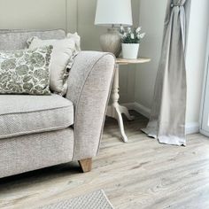 a living room scene with focus on the couch and pillows in front of the window