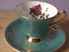 a cup and saucer sitting on top of a wooden table next to a wall