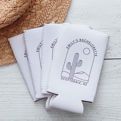 three white paper tags with the name and image of a cactus on them next to a straw hat