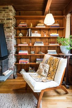 a living room with bookshelves and a fireplace in the center is featured on an instagram