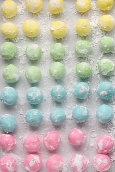 there are many different colored candies on the table together and one has white sprinkles all over it