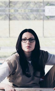 a woman sitting on the ground wearing glasses