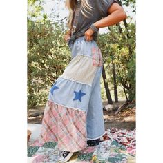 a woman standing on top of a patchwork blanket