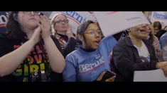 several people are holding signs and shouting at the same time as they stand in a crowd