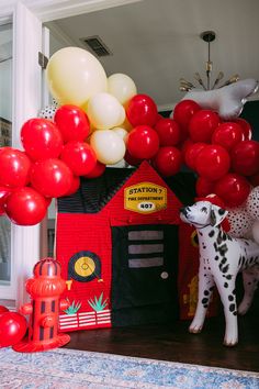 a fire truck birthday party with balloons and a dog house on the front door for decoration