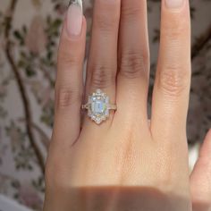 a woman's hand with an engagement ring on top of her left hand, and the other half of her right hand