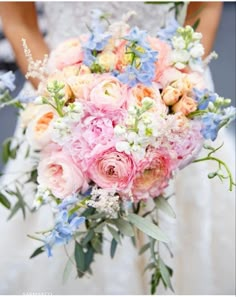 a bridal holding a bouquet of pink and blue flowers