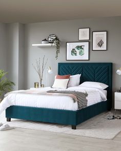 a bedroom with grey walls, white bedding and green headboard in the middle