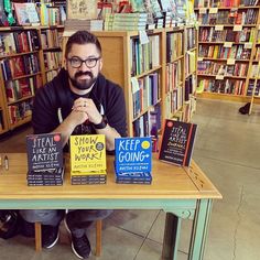 a man sitting at a table with books on it