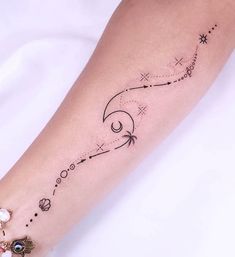 a woman's arm with an arrow and stars tattoo on it