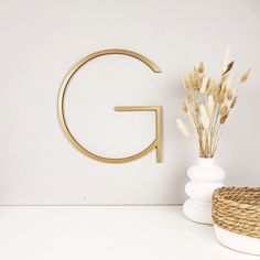 there is a vase with some flowers next to the letter g