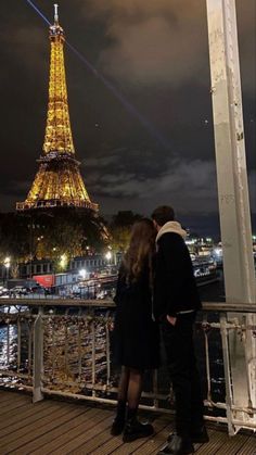 two people looking at the eiffel tower in paris