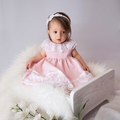 "Pink dress is made out of very soft, smooth Marchiano fabric. The neckline of the dress is finished with a beautiful lace in white. At the back of the dress a bow is attached made of the double-sided satin ribbon. The lining in the dress is made out of the cotton batiste, thanks to which it does not irritate the child's skin. The bottom of the dress is finished with guipure and double-sided satin belt. The model has an invisible zipper. The dress is available in four colour options: WHITE, BLUE White Bow Dress For First Birthday, White Dress With Bow For First Birthday, Pink Lace Dress For First Communion, Sleeveless Baptism Dress With Bow, Elegant Pink Baptism Dress With Lace Bodice, Elegant Pink Lace Baptism Dress, Pink Lace Bodice Dress For Baptism, Fitted Princess Dress With Satin Bow For Baptism, Princess-style Baptism Dress With Bow