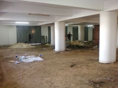 two men are standing in the middle of an empty parking garage that is under construction