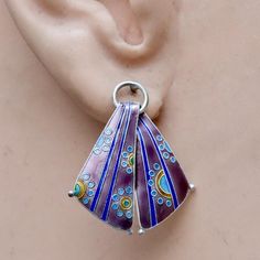 A decorative scarf hangs in purple and shades of blue. Sterling silver base, coated with vibrant enamel. Size: 1 1/8 inches tall.The Shashi earrings offered here are vintage stock from the 1970's and 1980's. They were designed by the Shashi Singapuri, crafted by hand, and were part of a line featured on the cover of vogue (quite a handful of times) and numerous other fashion magazines. Retro Purple Jewelry For Gifts, Blue Enamel Earrings With Artistic Design, Cover Of Vogue, Violet Earrings, Cloisonne Earrings, Purple Scarf, Art Jewelry Design, Wrist Jewelry, Purple Scarves