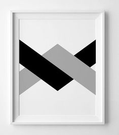 a black and grey geometric art print hanging on a wall next to a white frame