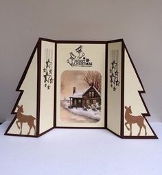 a christmas card with an image of a house in the snow and a deer on it