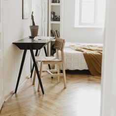 a room with a bed, desk and chair in it